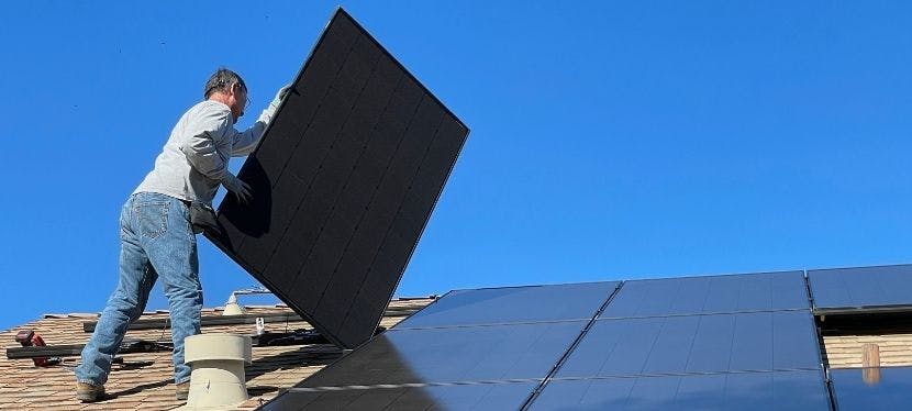 Homme qui retire des panneaux solaires pour les recycler