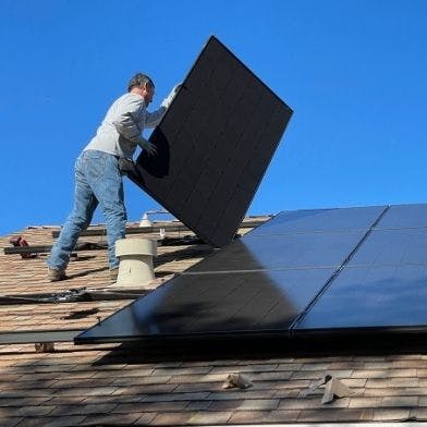 Homme qui retire des panneaux solaires pour les recycler