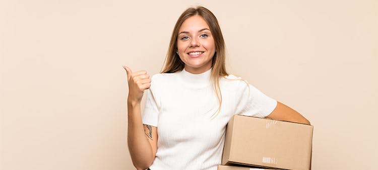 Une femme avec des cartons de déménagement dans les bras