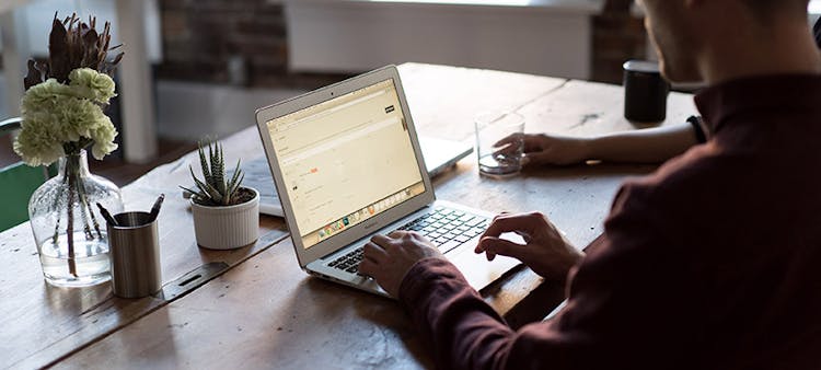 Une personne travaillant sur son ordinateur à son domicile