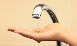 Un robinet d'eau coulant sur des pièce de monnaie tenues par une main humaine