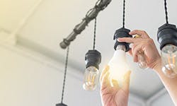 Un homme changeant une ampoule pour une ampoule basse consommation