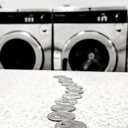 pièces de monnaie devant machines à laver