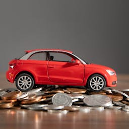 Voiture sur des pièces de monnaie pour symboliser le prix d'une voiture électrique
