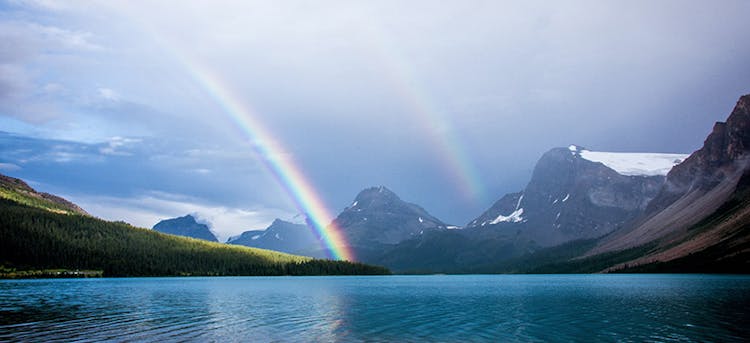 Arc-en-ciel sur un lac près des montagnes