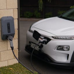 Voiture blanche et noir en train de recharger sur une borne