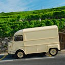 Une vielle camionnette pour un déménagement garée à côté de vignes 