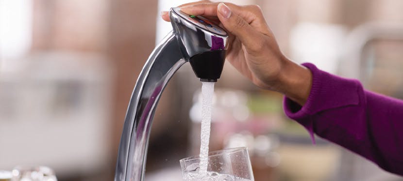 Une femme qui se sert de l'eau à une fontaine Brita