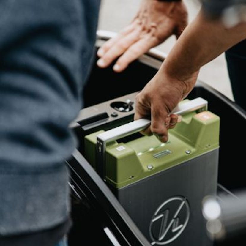 Personne qui installe une batterie de voiture électrique.