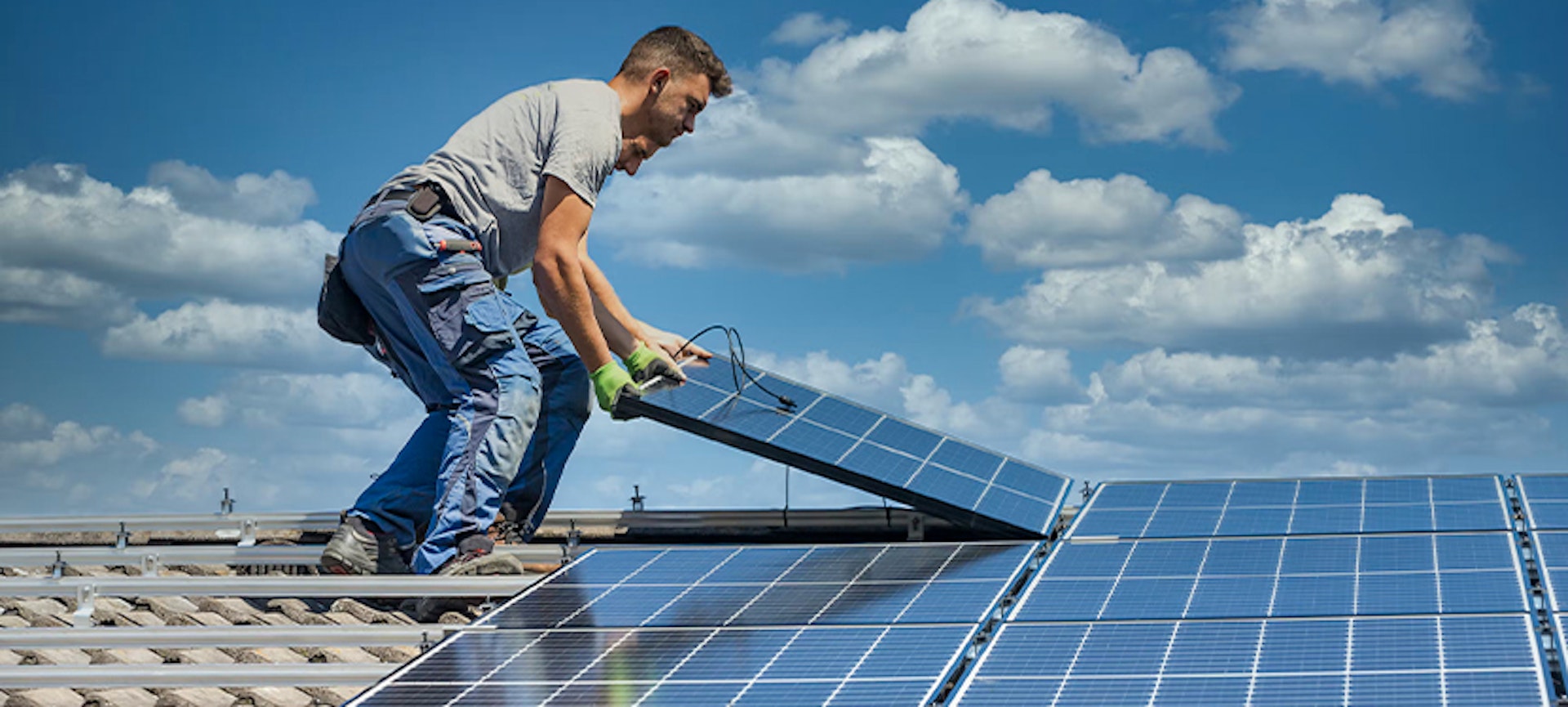 Deux hommes installant des panneaux solaires photovoltaïques en toiture