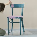 Une femme qui redonne une seconde vie à une chaise pour son déménagement en la peignant