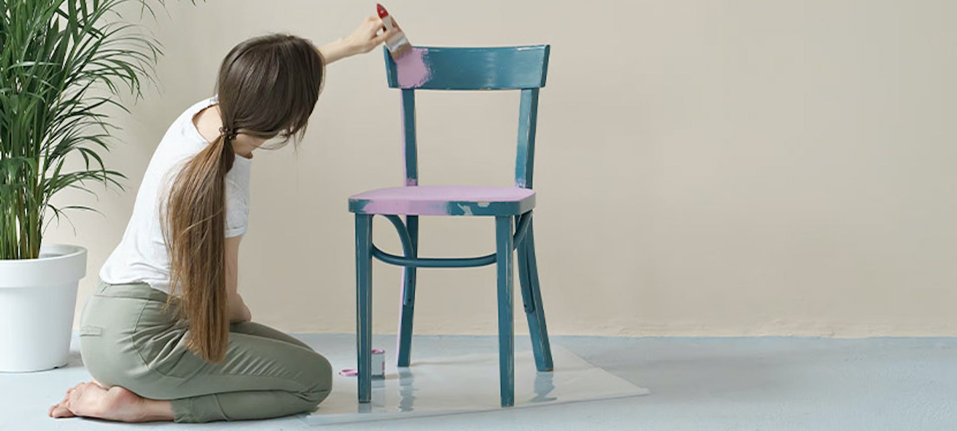 Une femme qui redonne une seconde vie à une chaise pour son déménagement en la peignant