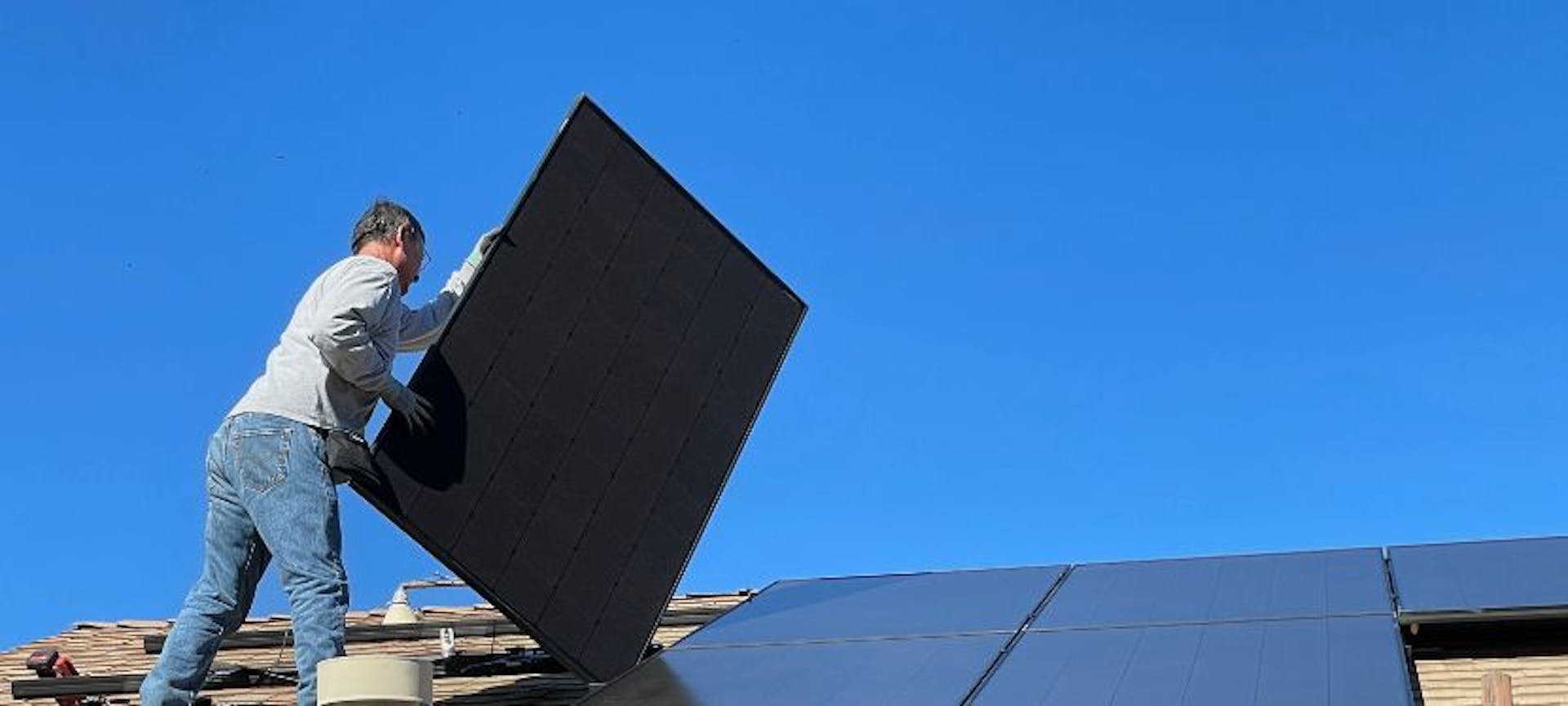 Installateur qui pose des panneaux solaires monocristallins