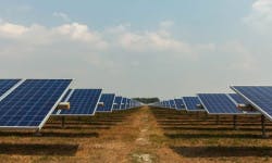 Photo d'une ferme solaire, avec une quantité de panneaux photovoltaïques installés dans un champ