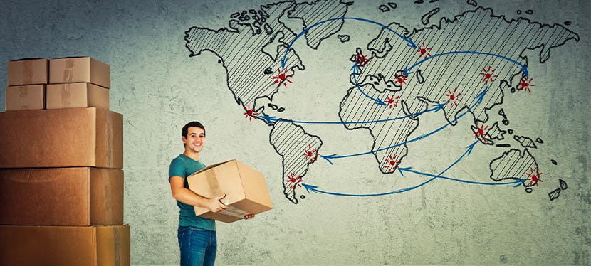 Un homme tenant un carton à côté d'une carte du monde qui déménage à l'international