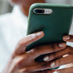 Une femme tenant un téléphone dans ses mains : la nouvelle fonctionnalité pour les clients ayant souscrits à l'offre d'électricité locale