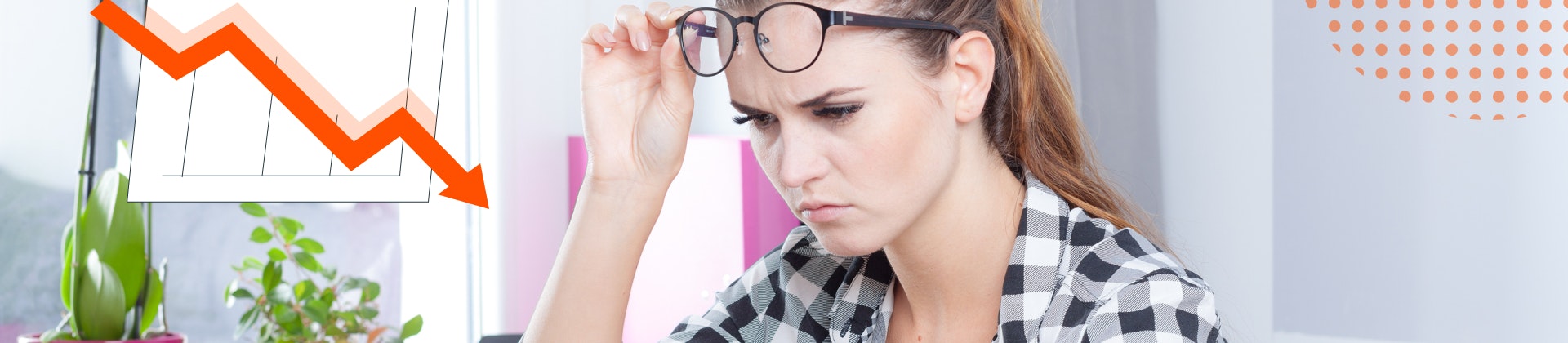 A woman looking closely at a computer with a frown. A chart with a downward trajectory.