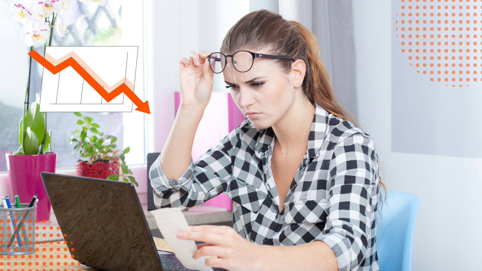 A woman looking closely at a computer with a frown. A chart with a downward trajectory.
