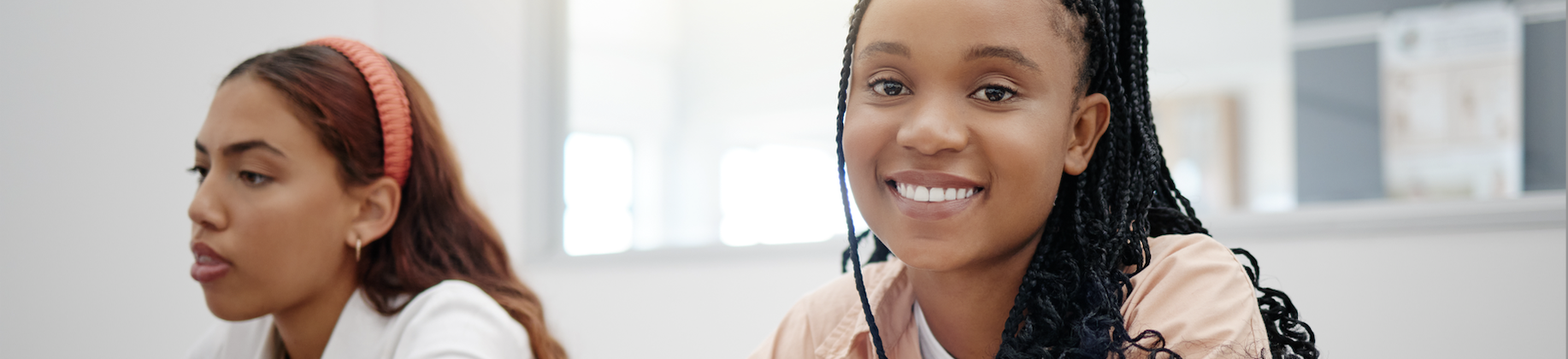 Two female college students in class. What is student retention in higher ed?