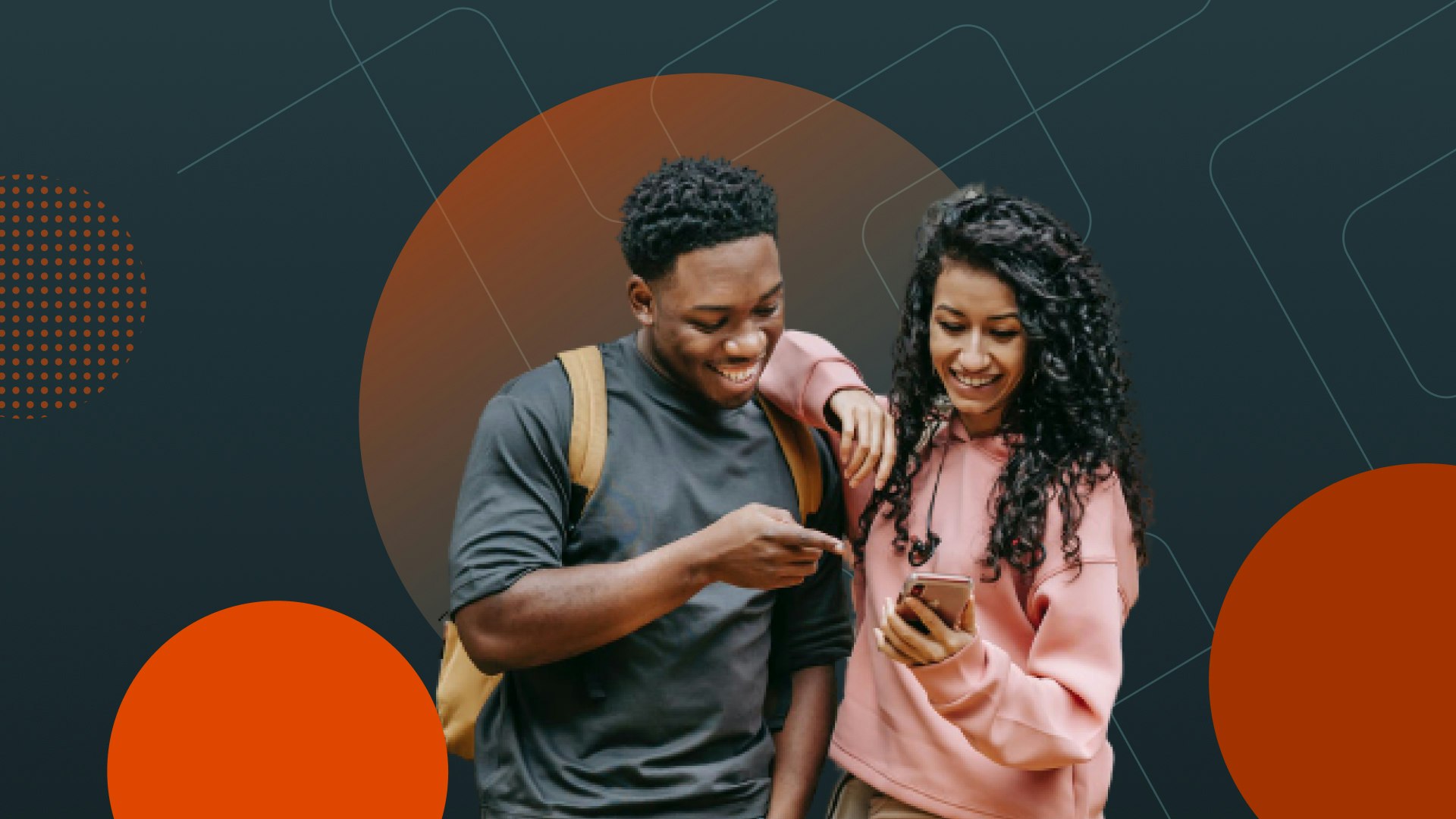 An image of two students looking at a phone and smiling.