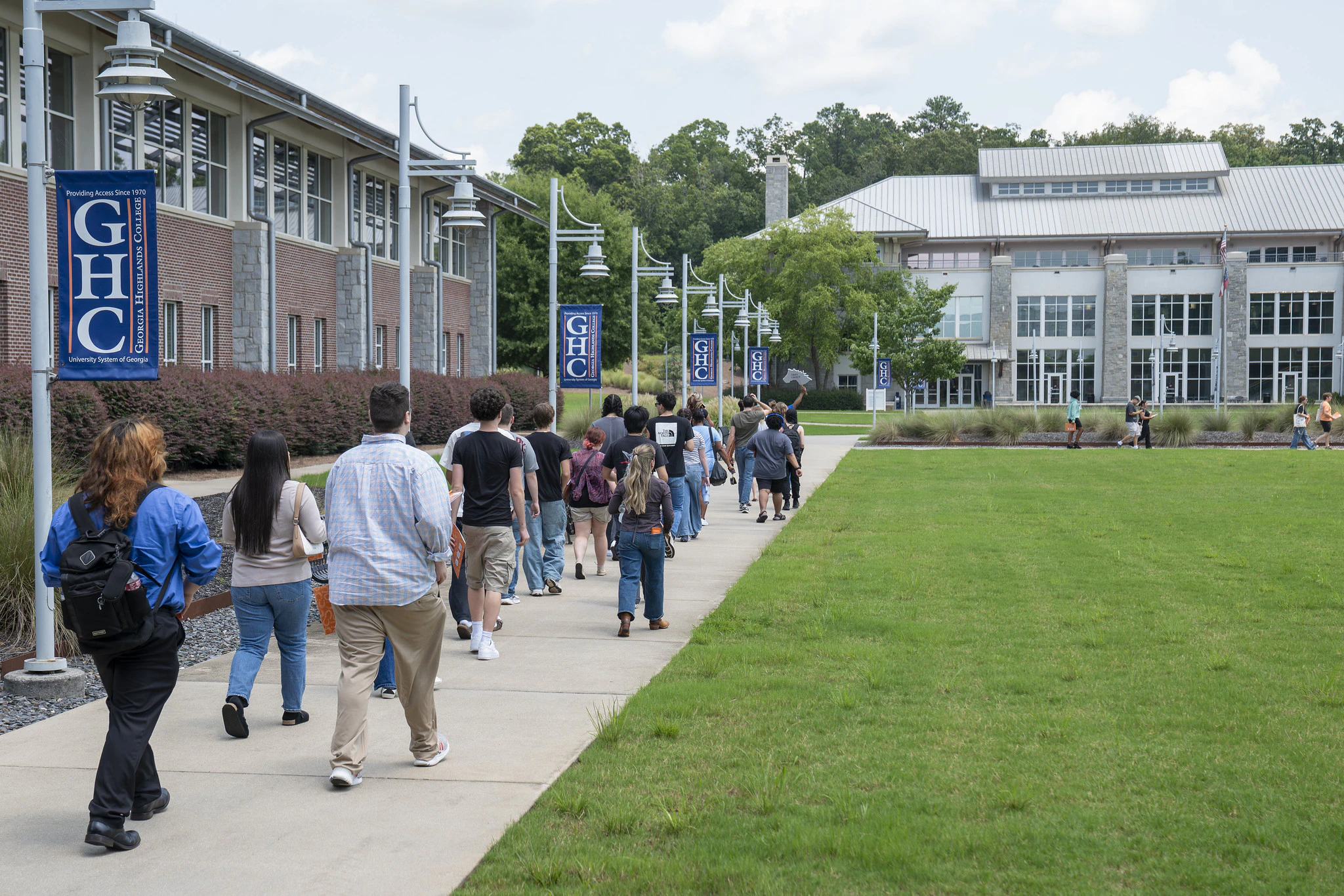 Prospective students on a campus tour walking past Georgia Highlands College banners