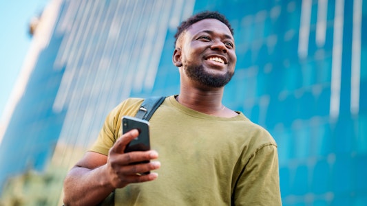 A man on his phone looking in front of him.