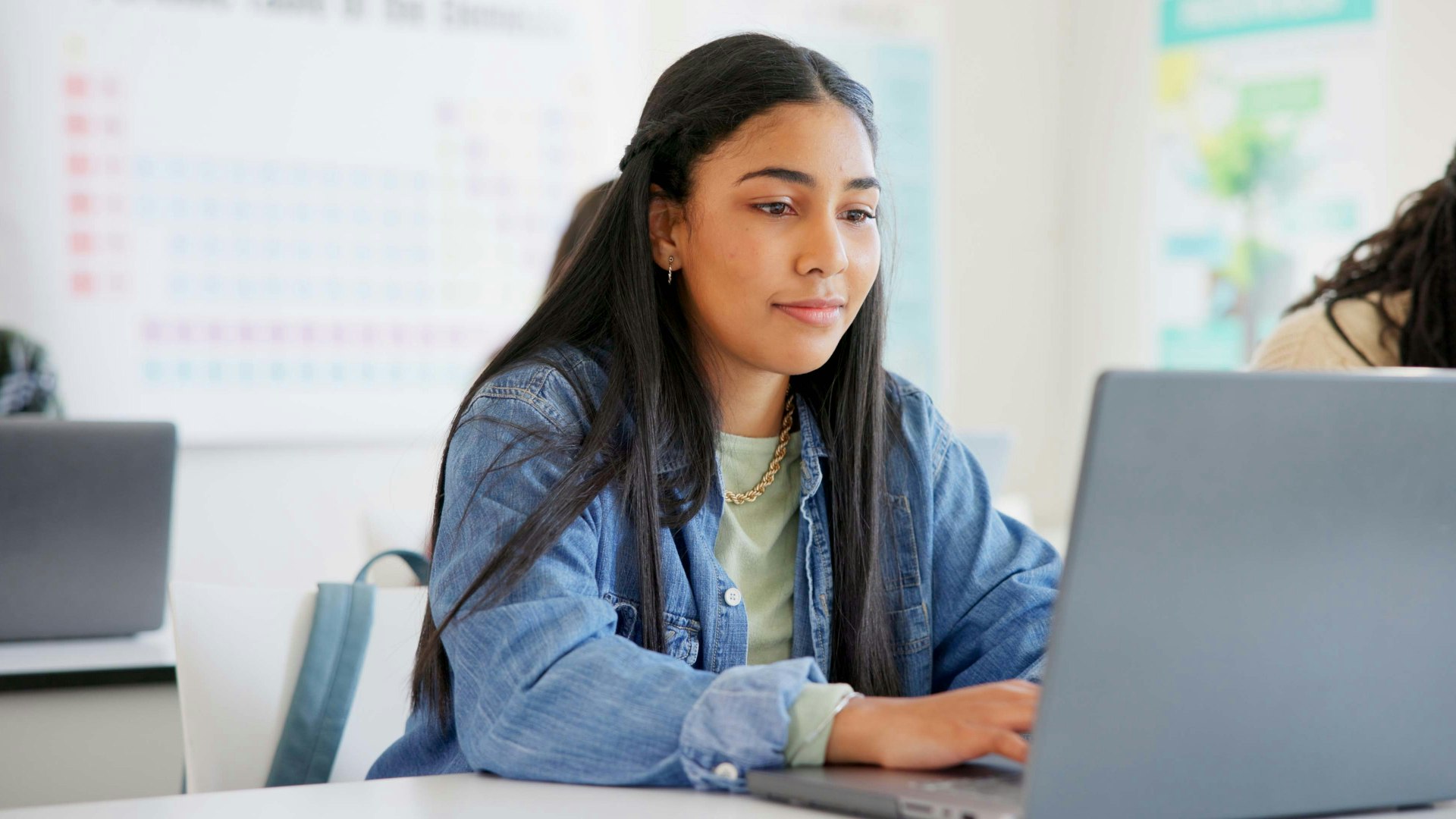 Student looking at laptop in a classroom.