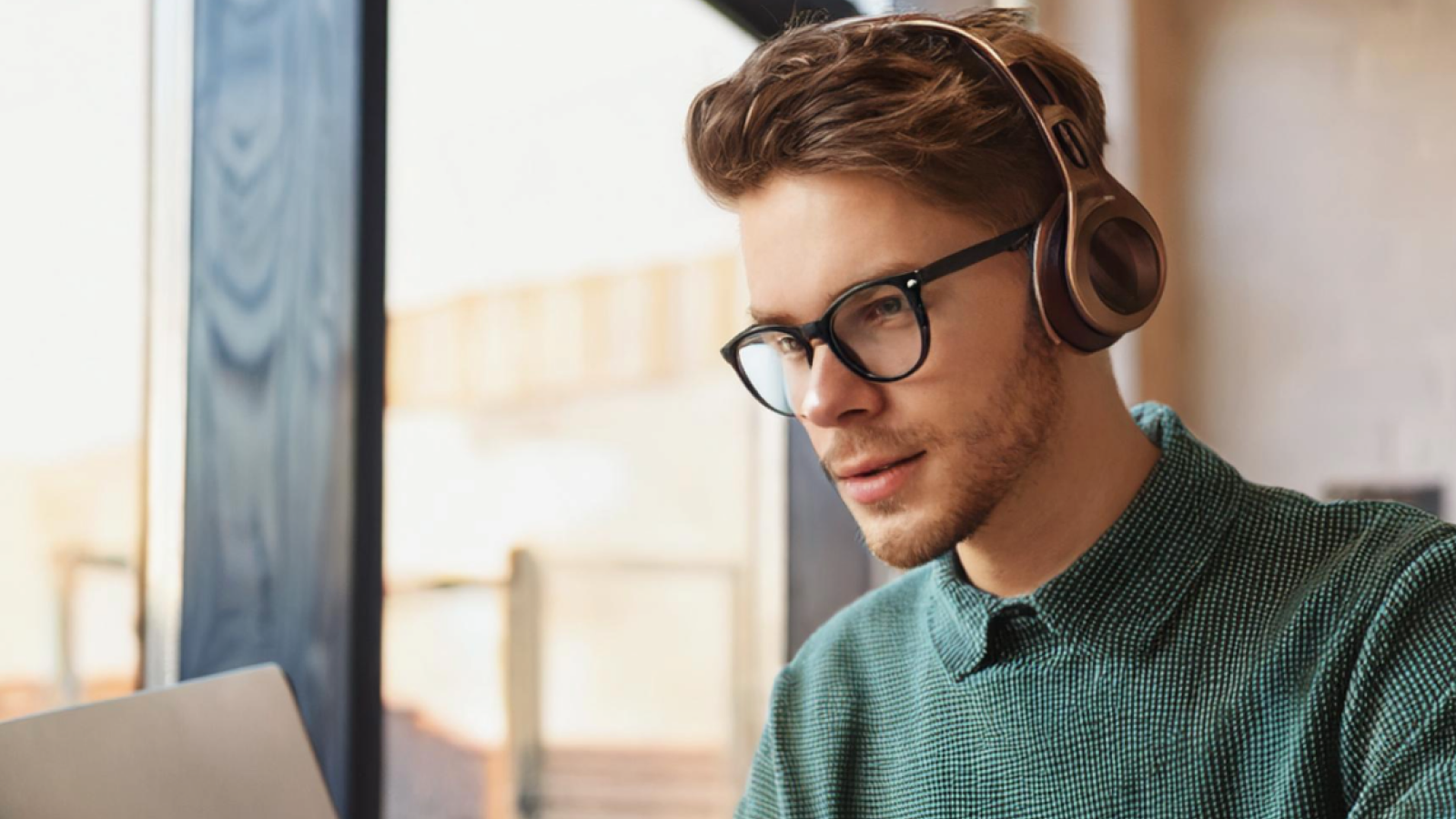 A student with headphones on is looking at this laptop.