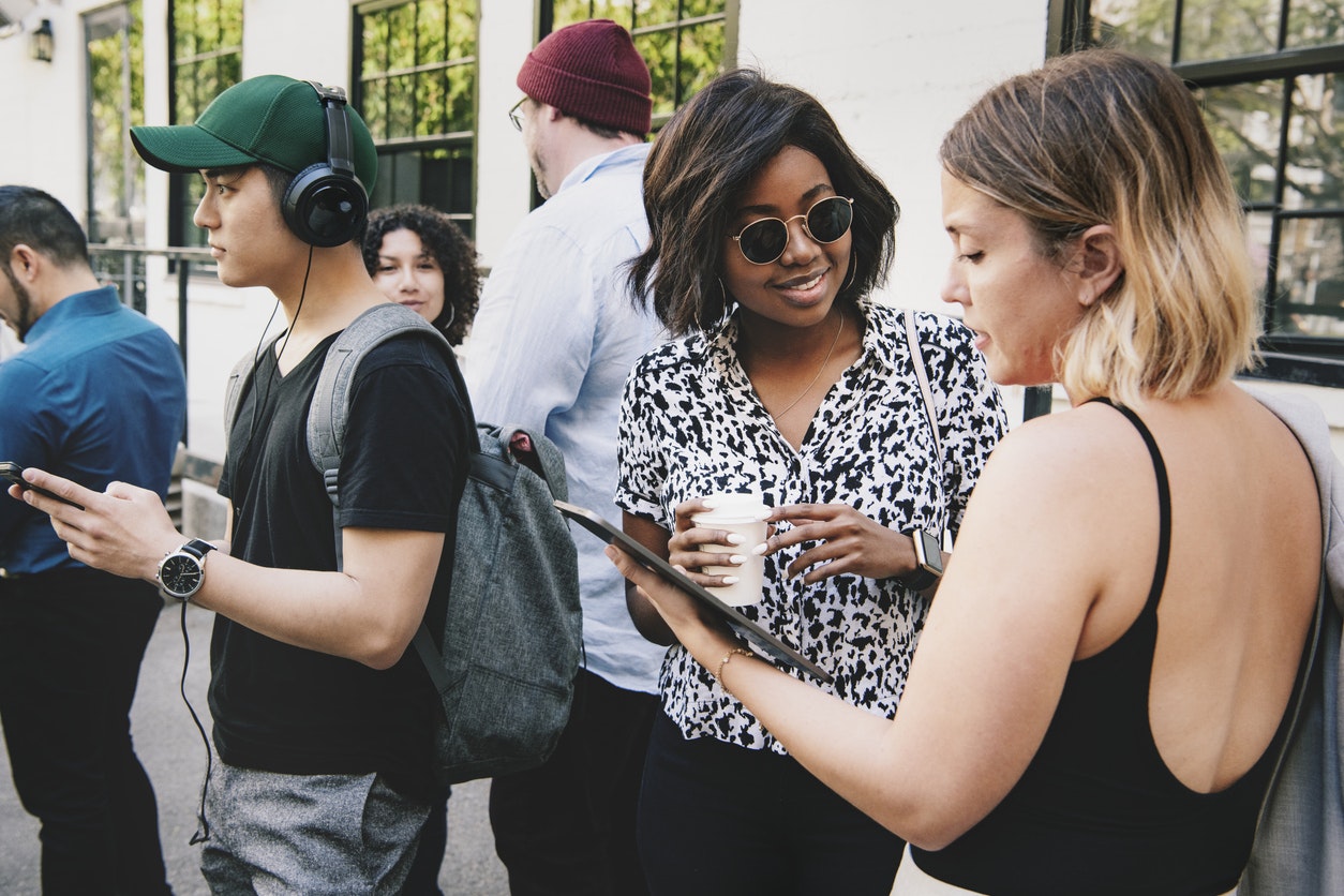 Students outside a school event looking at a digital tablet