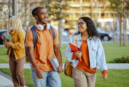 Two students walking to class together chatting.
