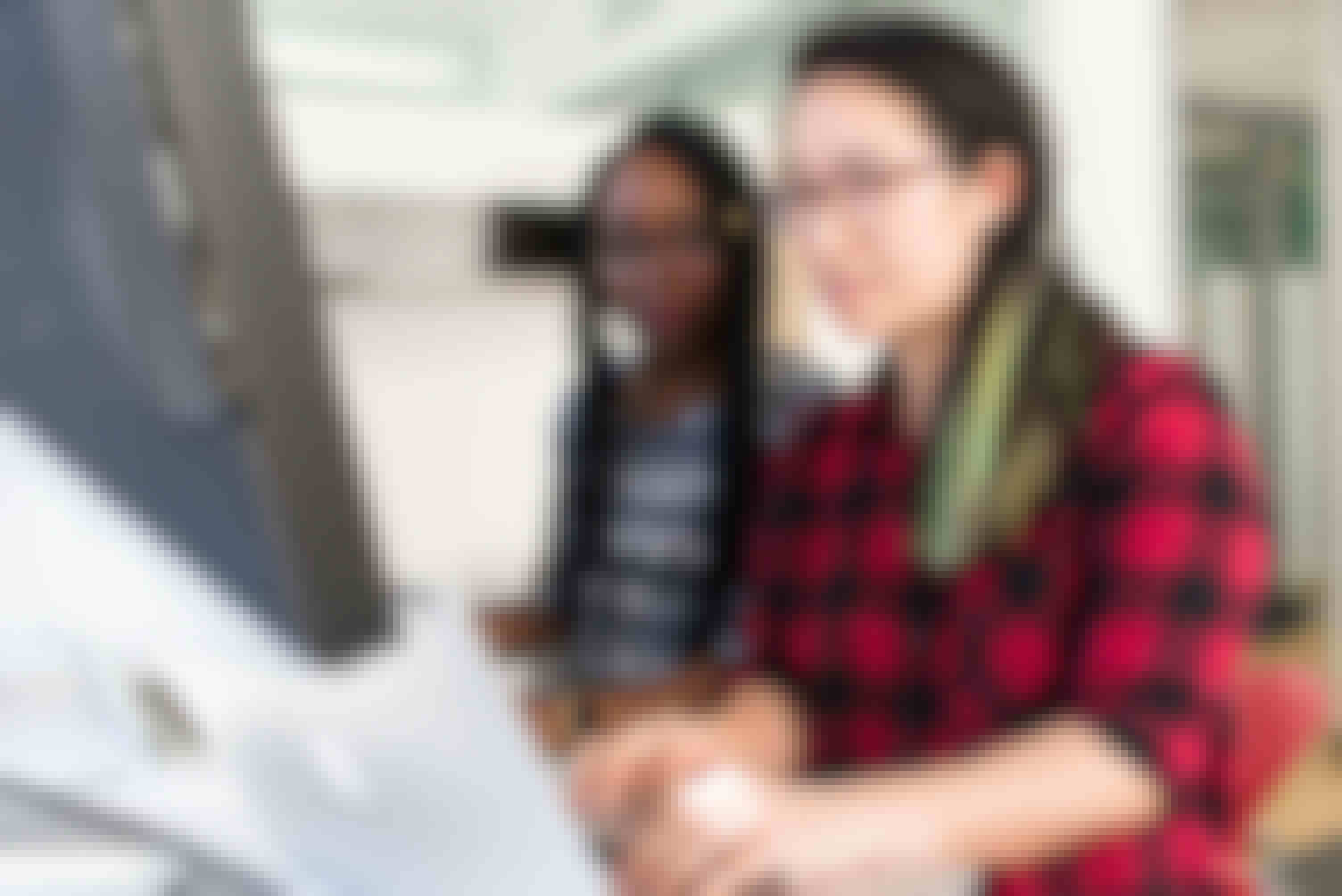 Two women working together at a standing desk on their laptops