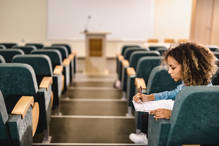 Black female student learning in an empty amphitheater. Overcoming the Challenges of Declining Student Enrollment in Higher Education