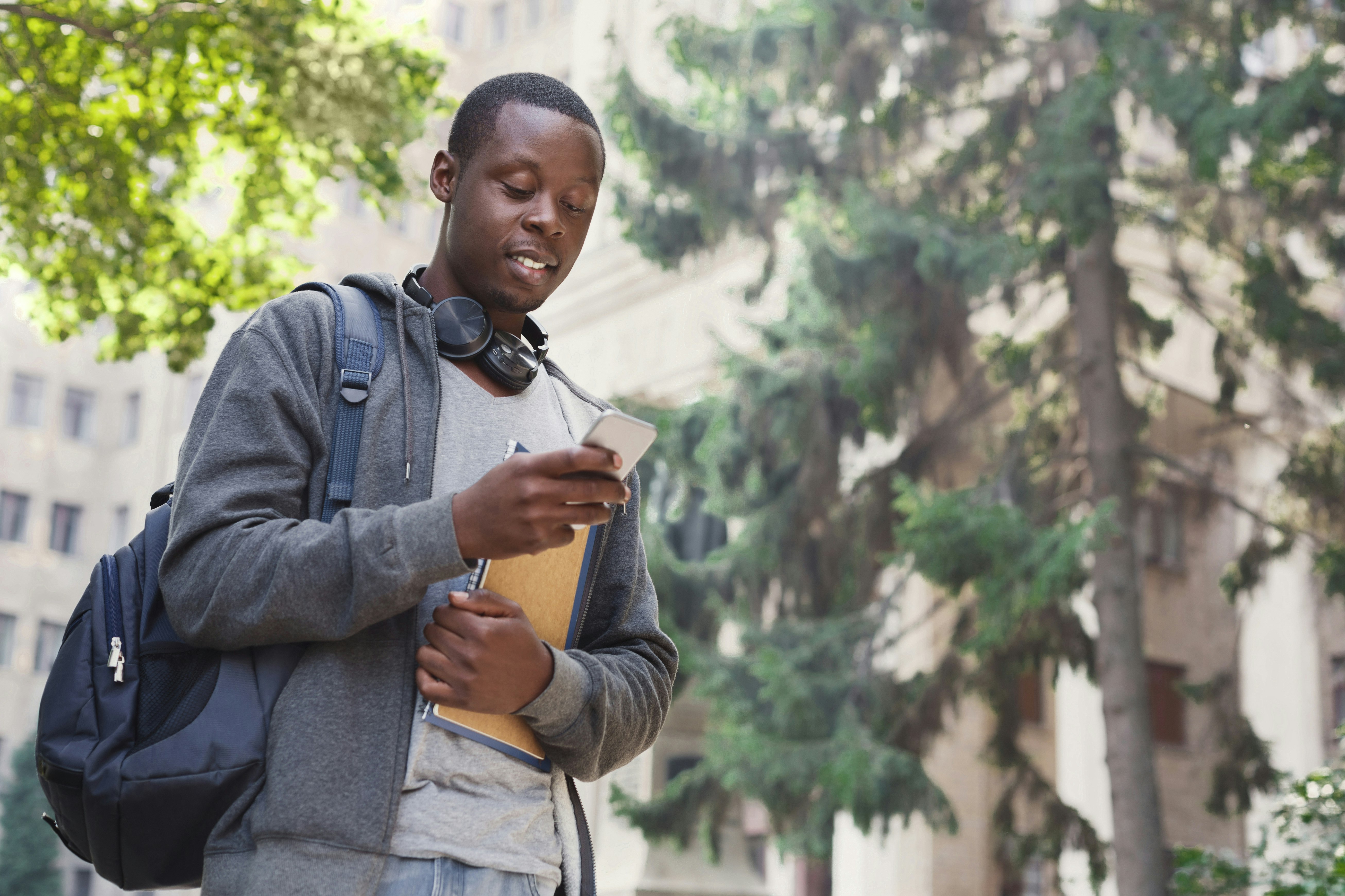 Black male student looking at his direct admissions acceptance on his cell phone