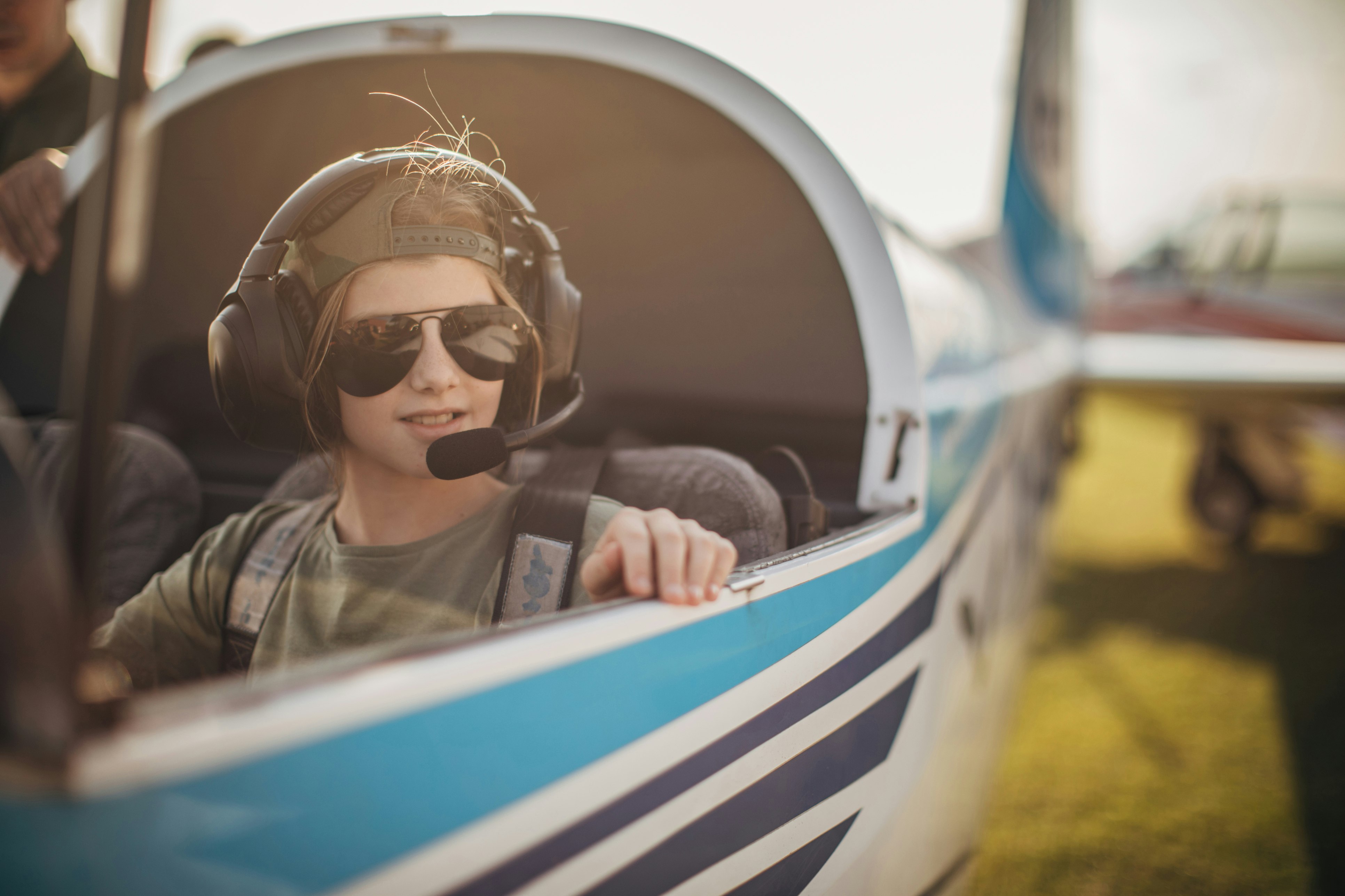 One girl, young girl pilot sitting alone i airplane cockpit.