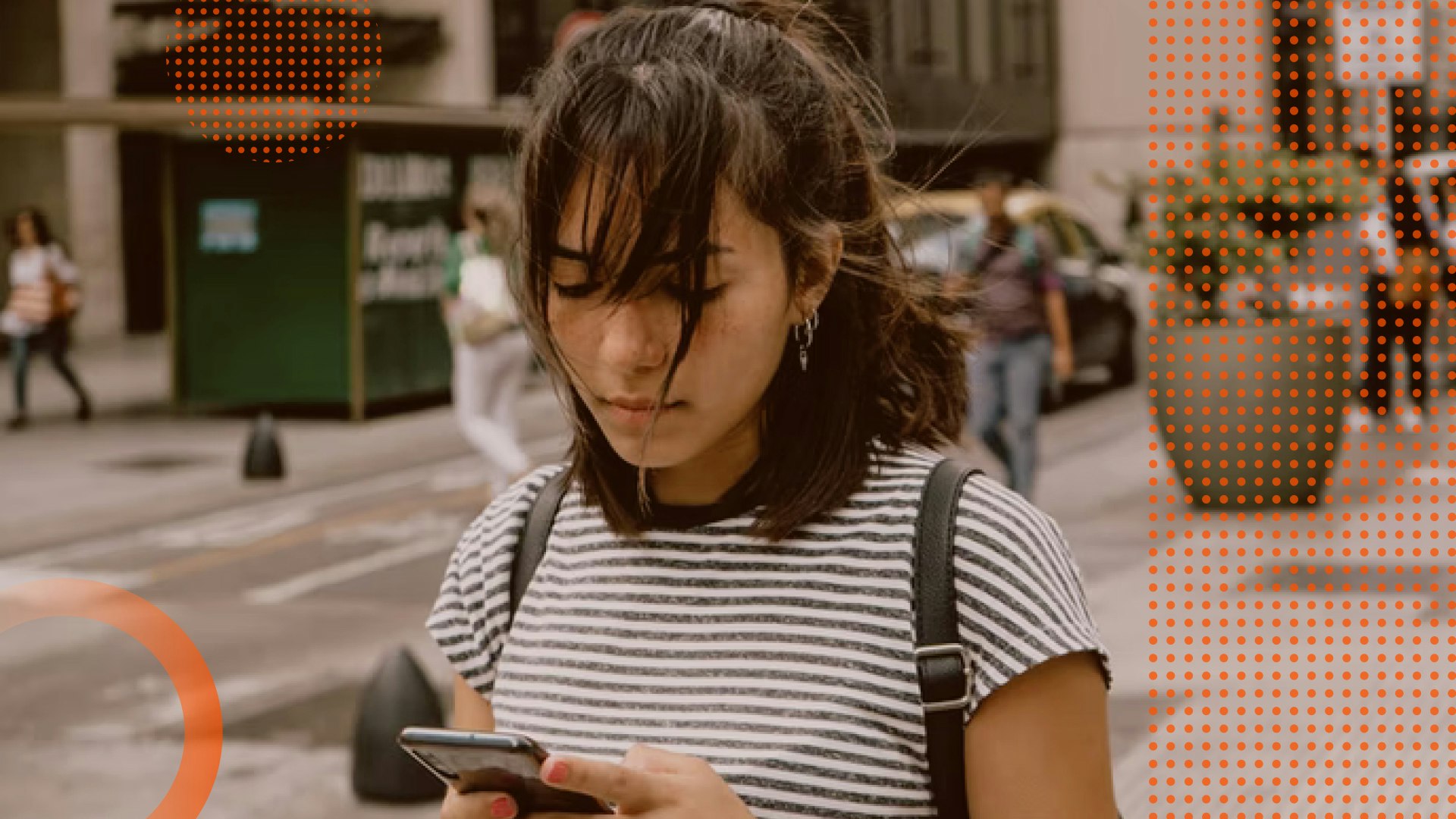Image of a young female looking down at her phone in her hands.