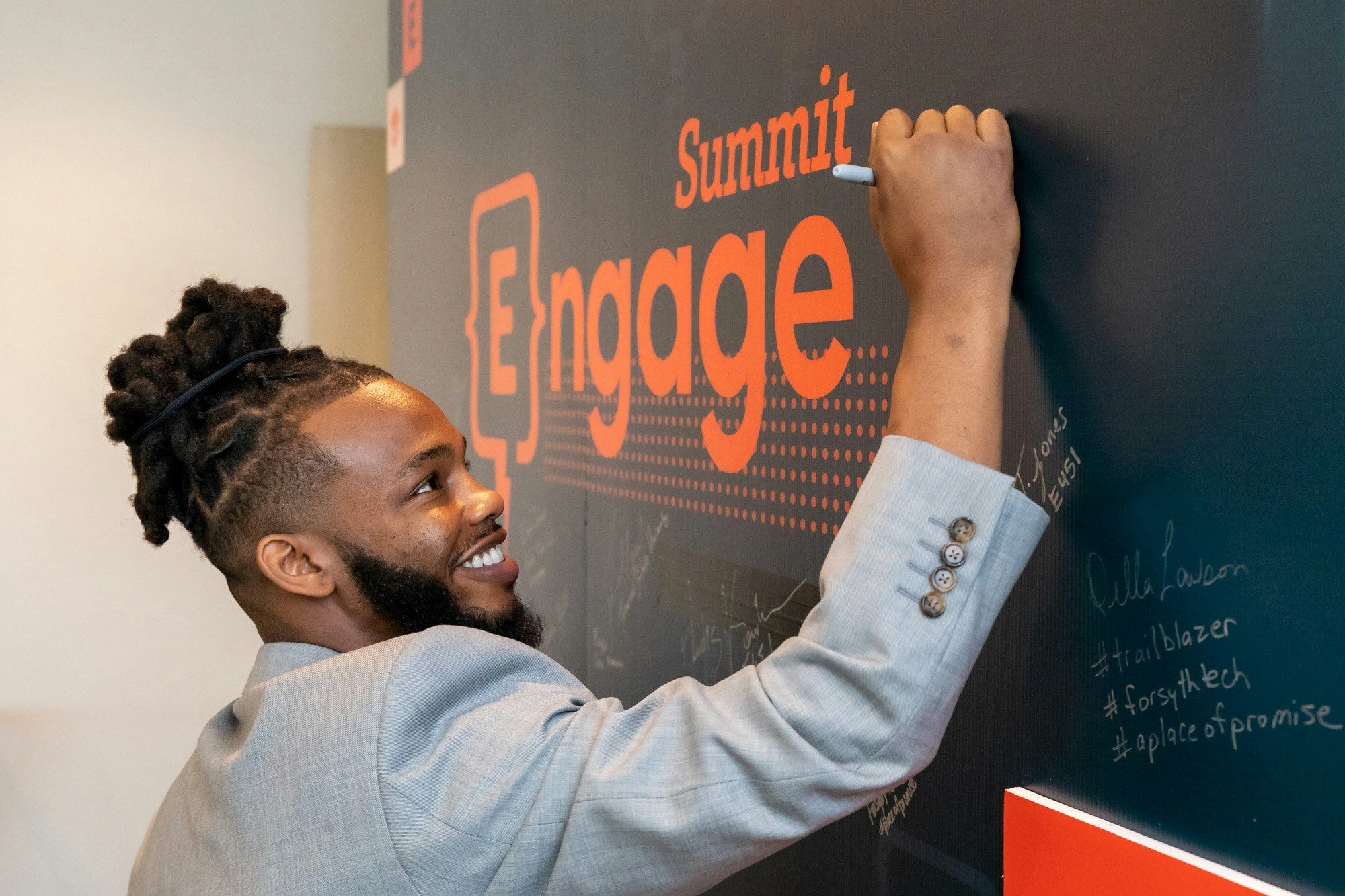 Travis writing on the chalkboard at Engage Summit