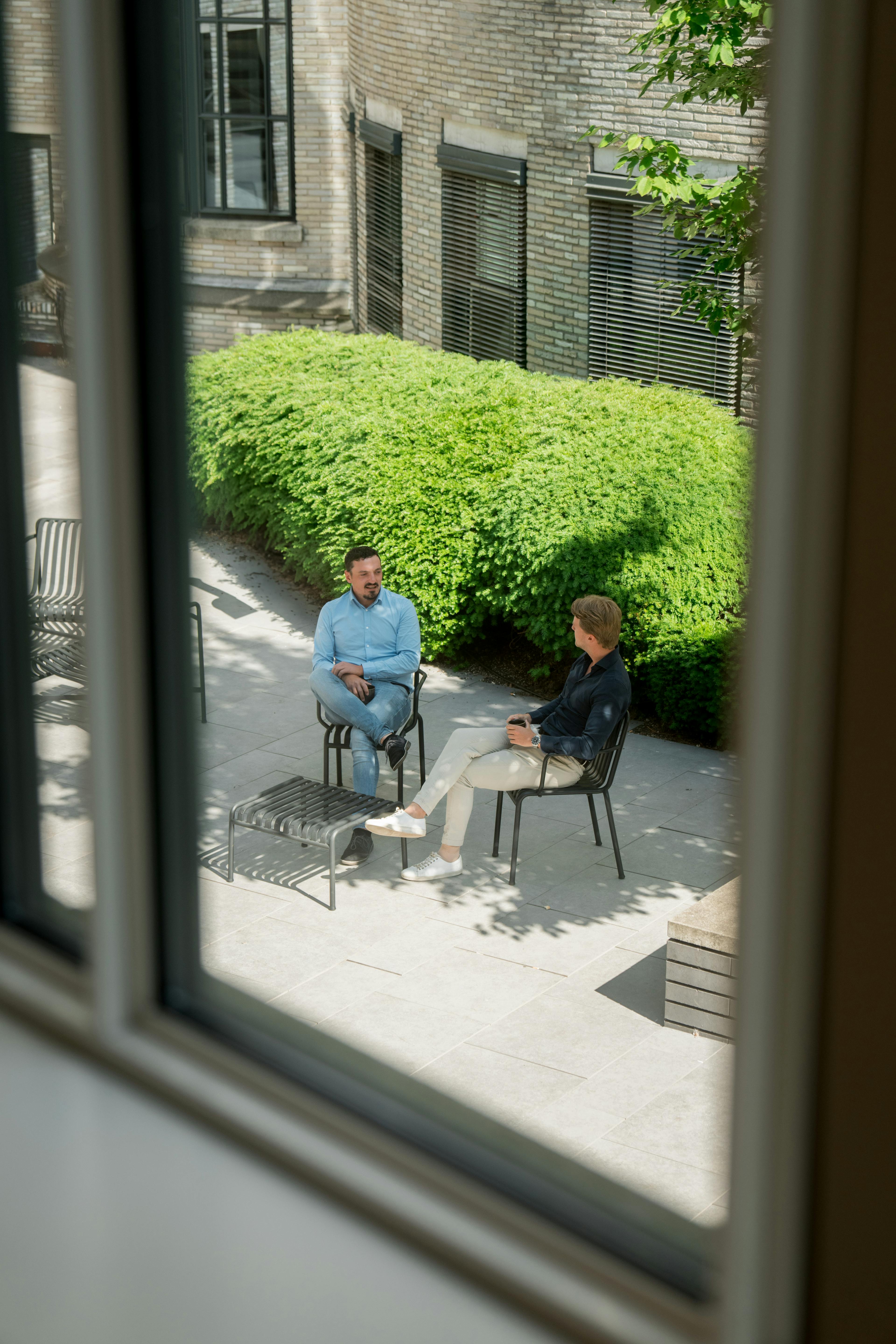Collega's in gesprek in de binnentuin van het kantoor.