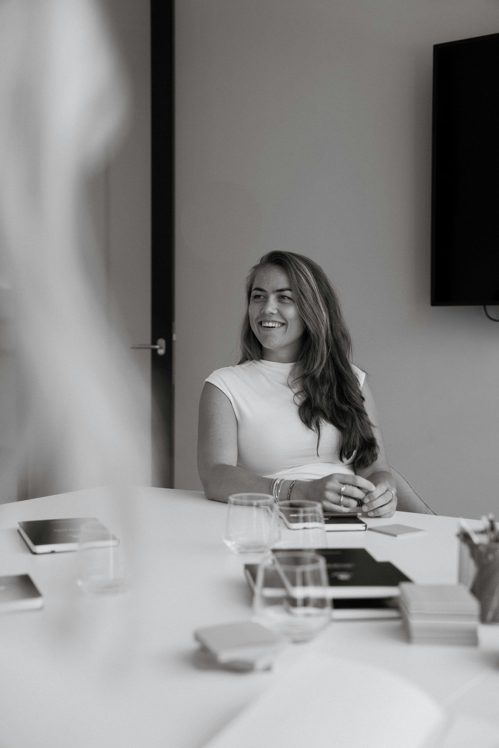 Collega lachende op kantoor zwart/wit.