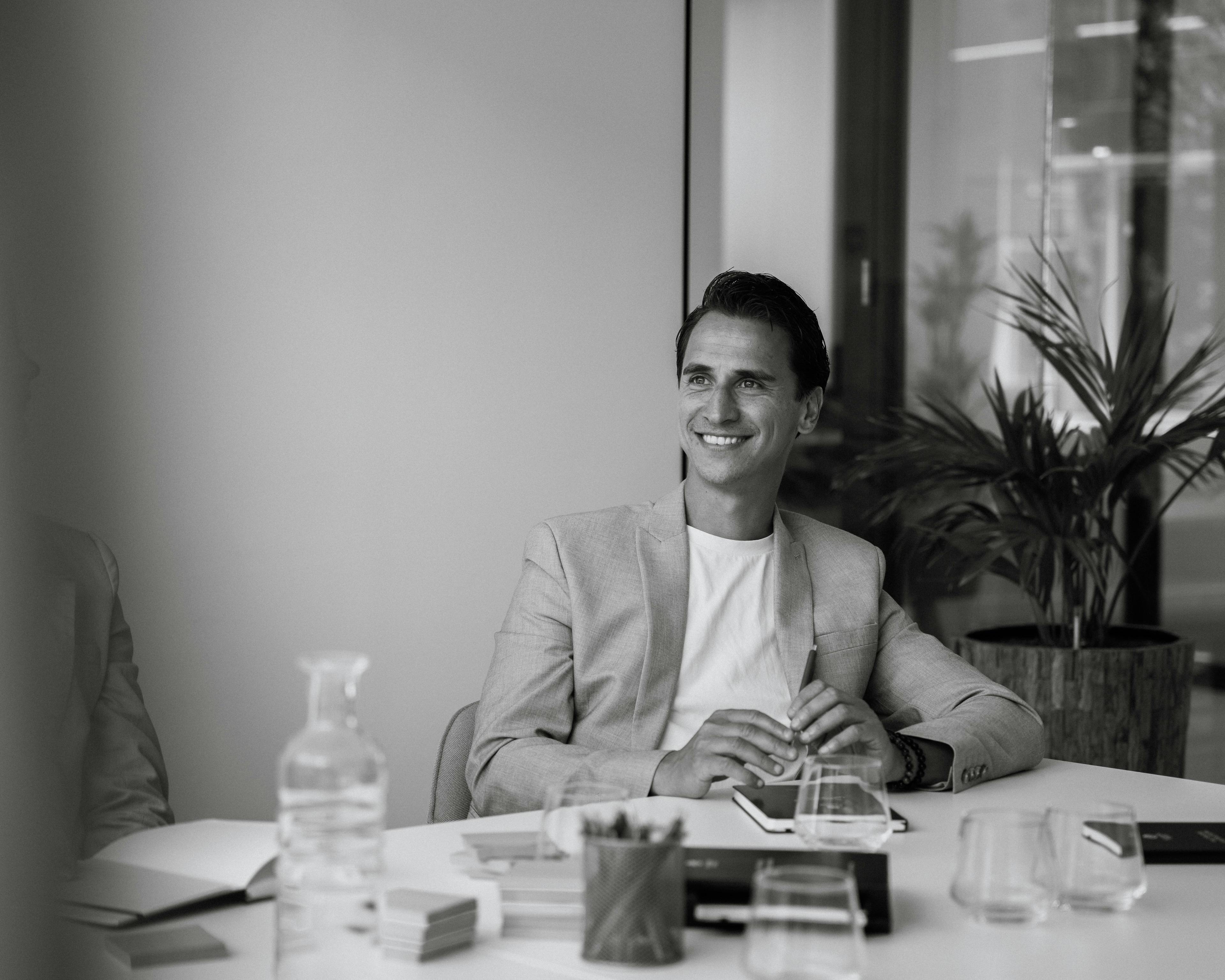 Glimlachende collega op kantoor zwart/wit.