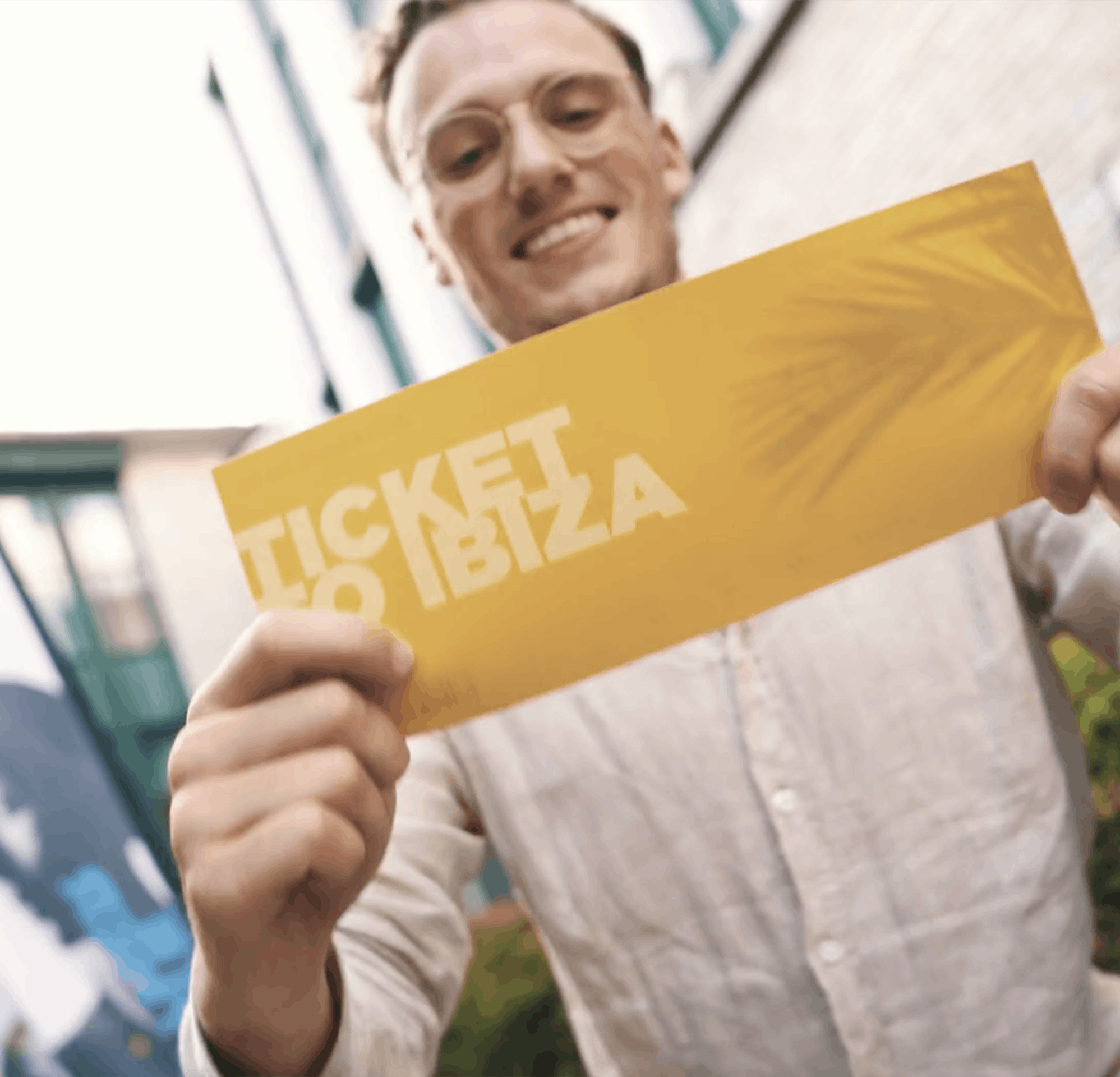 Medewerker Elevation Group met een ticket naar Ibiza in zijn hand.