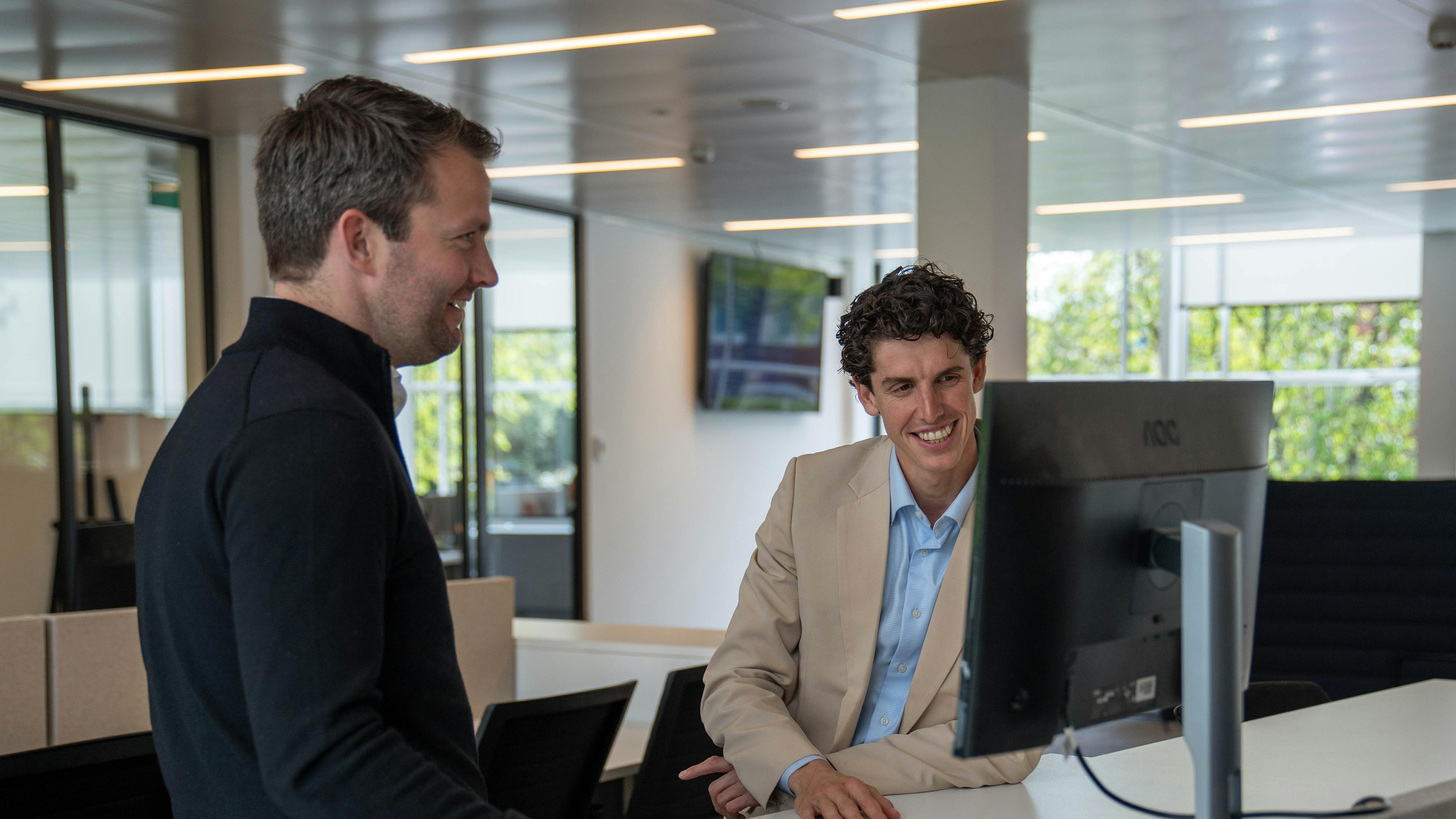 Twee werknemers van Elevation Group aan het werk op kantoor.