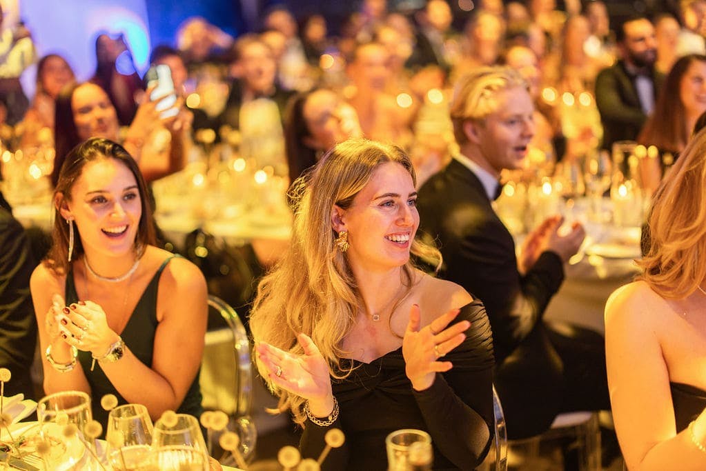 Medewerkers applaudiserend aan tafel.
