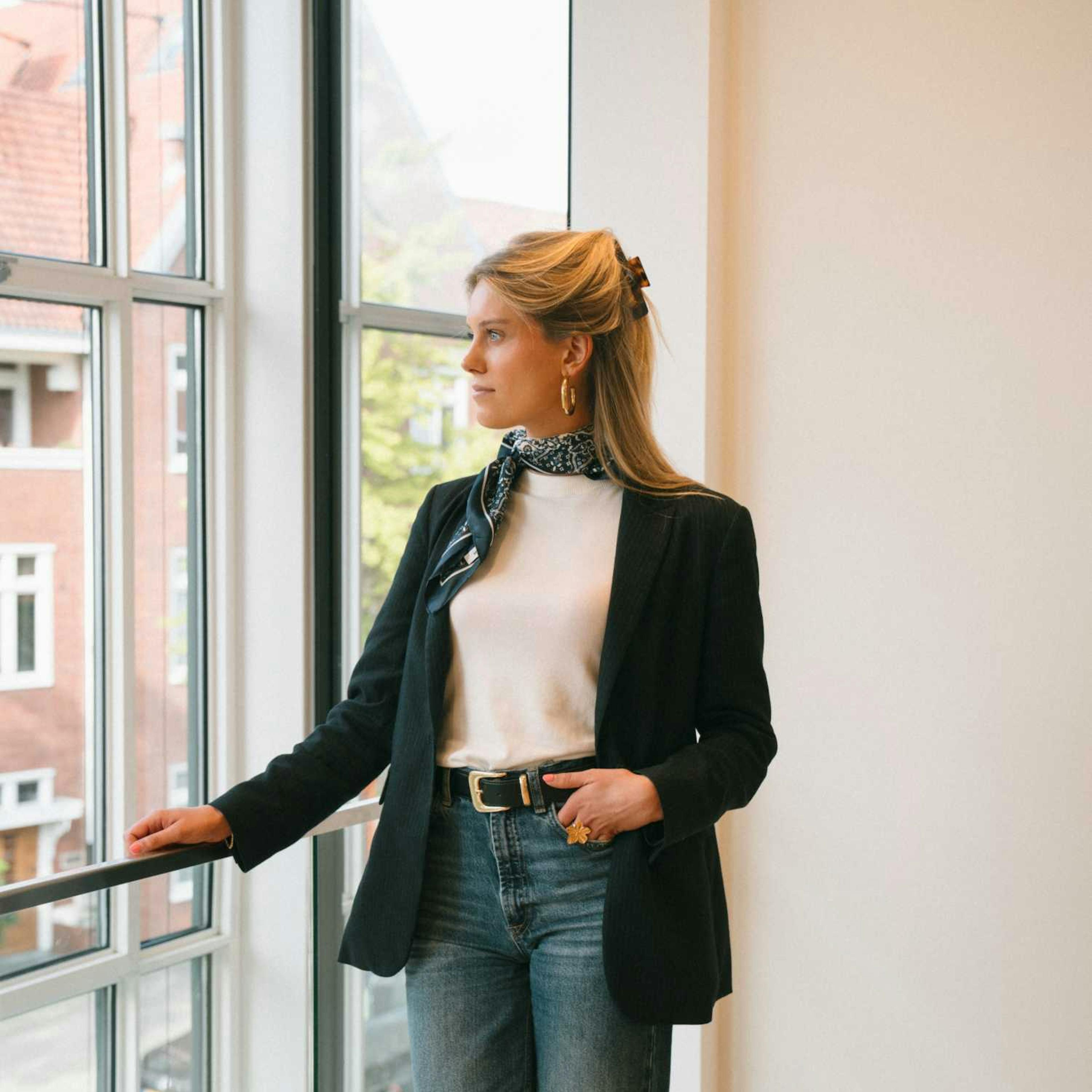 Willemijn staat in het kantoor van Elevation Group en kijkt uit het raam. 