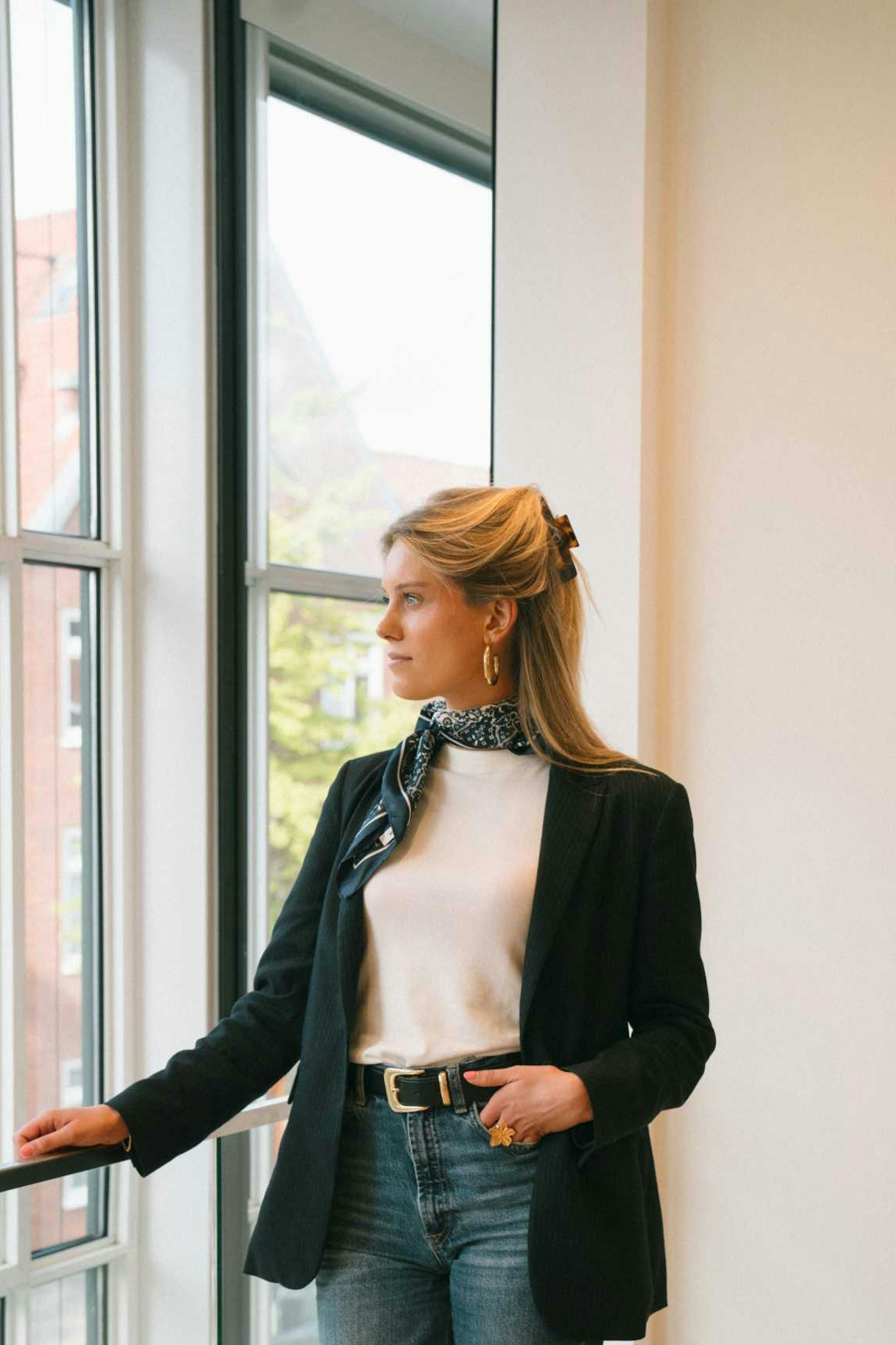 Willemijn staat in het kantoor van Elevation Group en kijkt uit het raam. 