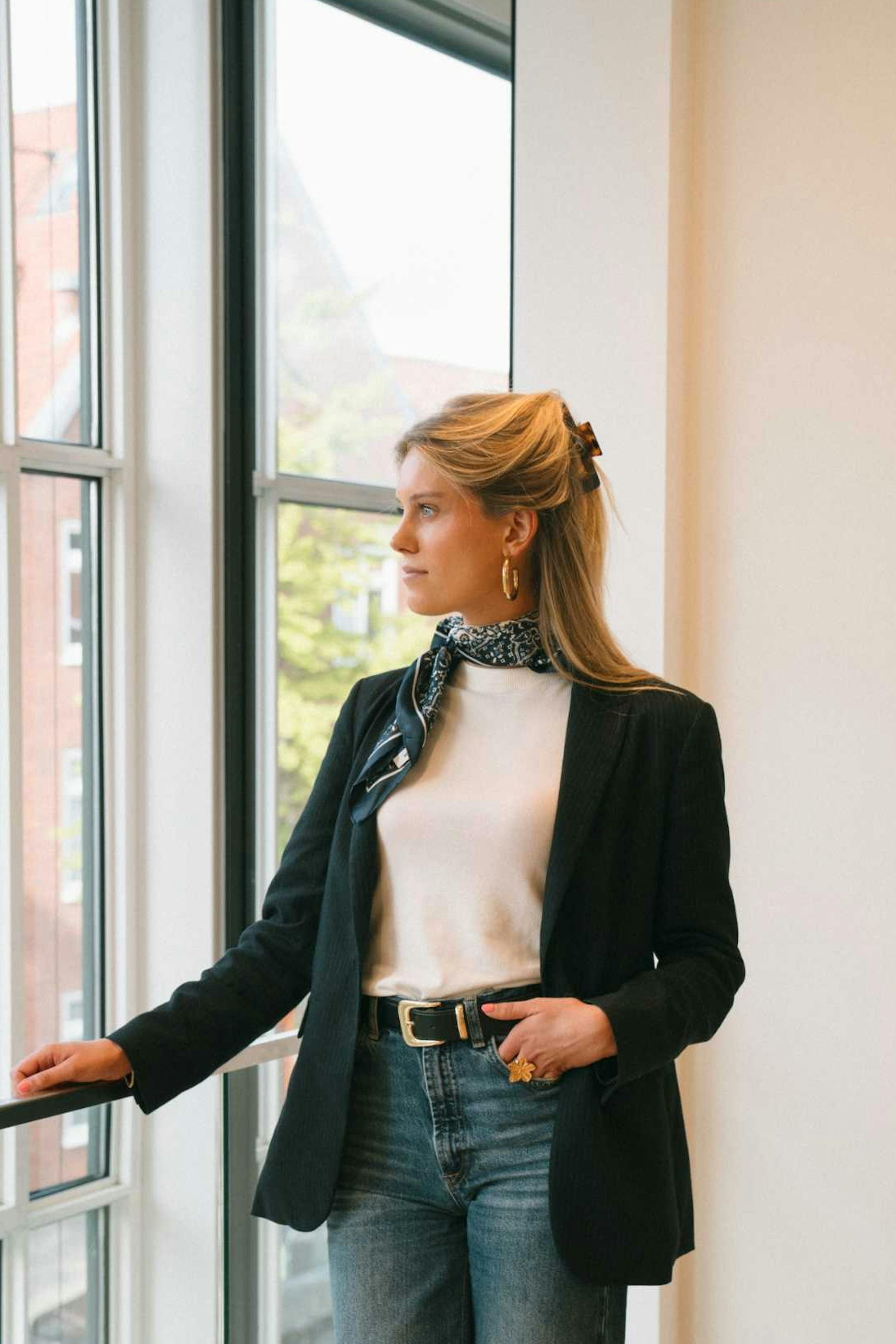 Willemijn staat in het kantoor van Elevation Group en kijkt uit het raam. 