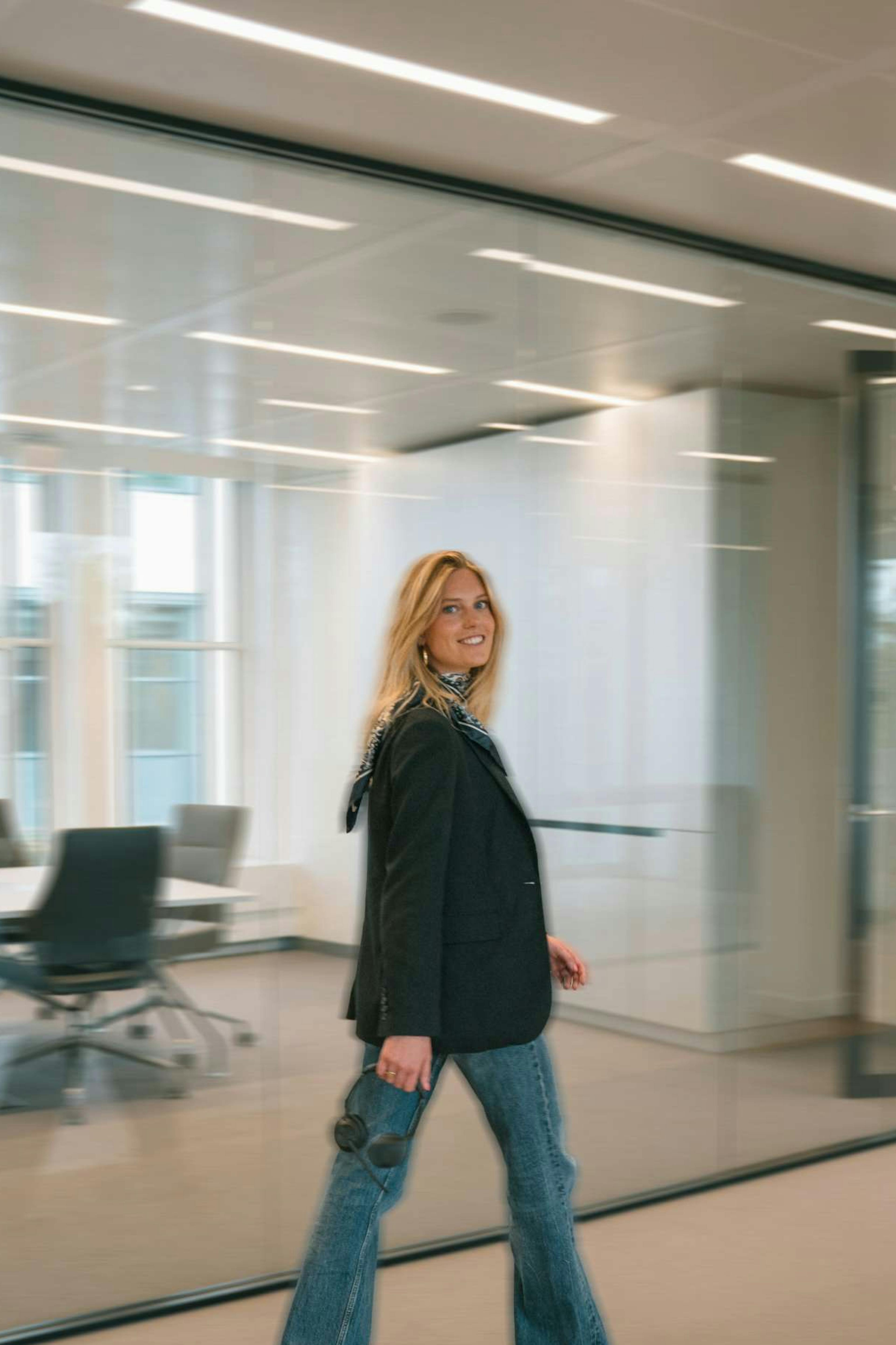 Willemijn loopt lachend door het kantoor van Elevation Group. 