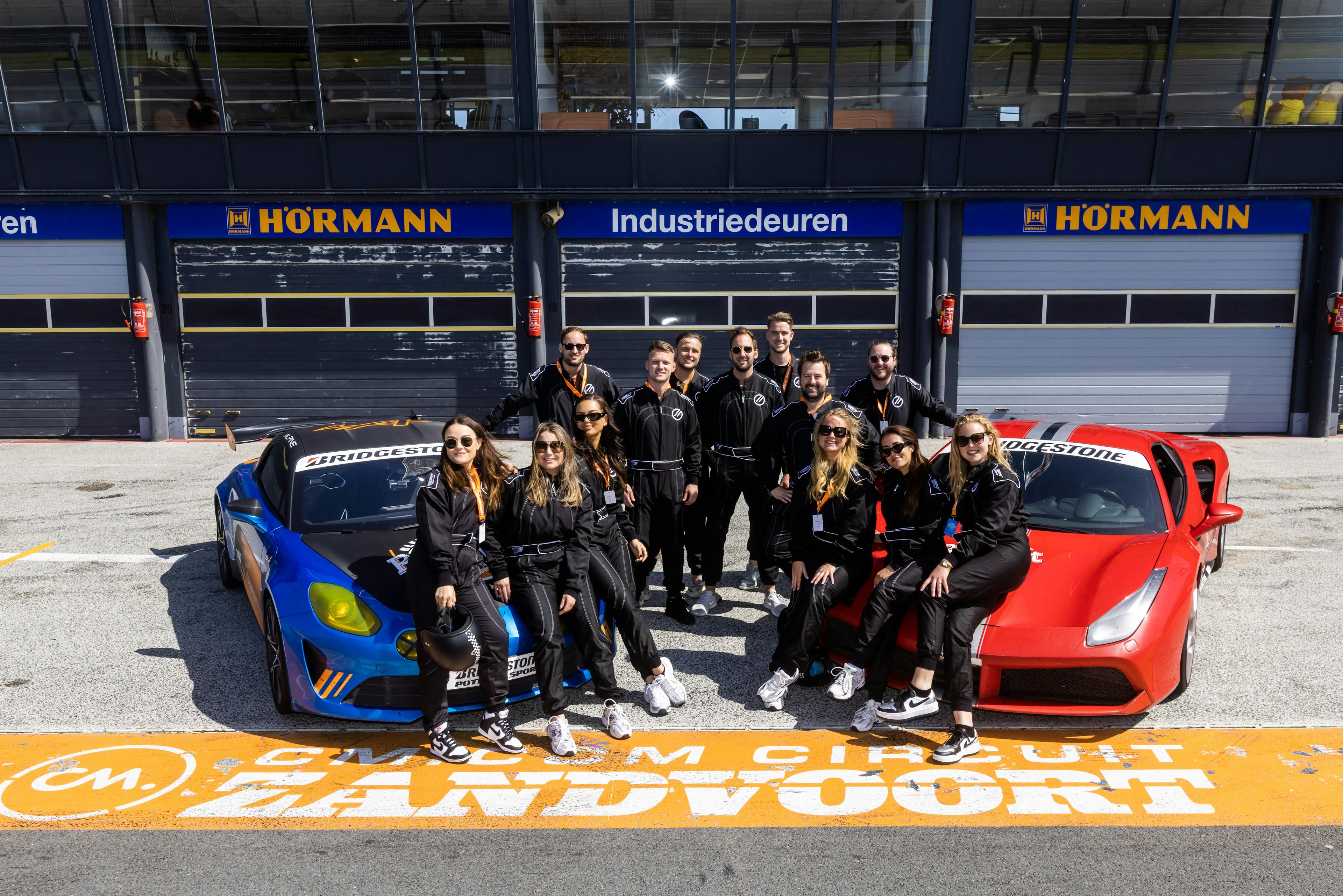 Medewerkers op event met raceauto's.