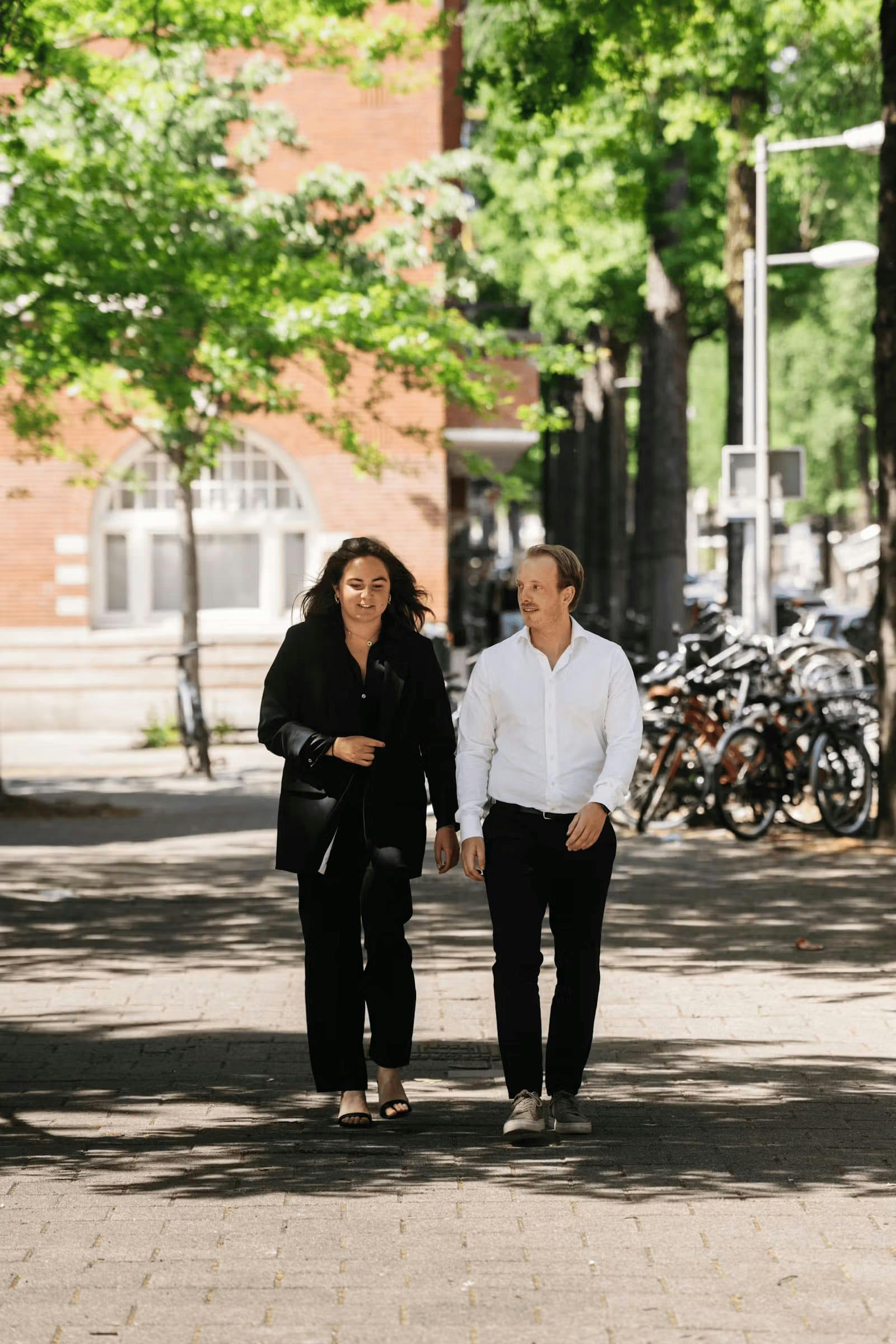 Medewerkers van Elevation Partners die in de stad lopend een gesprek houden.