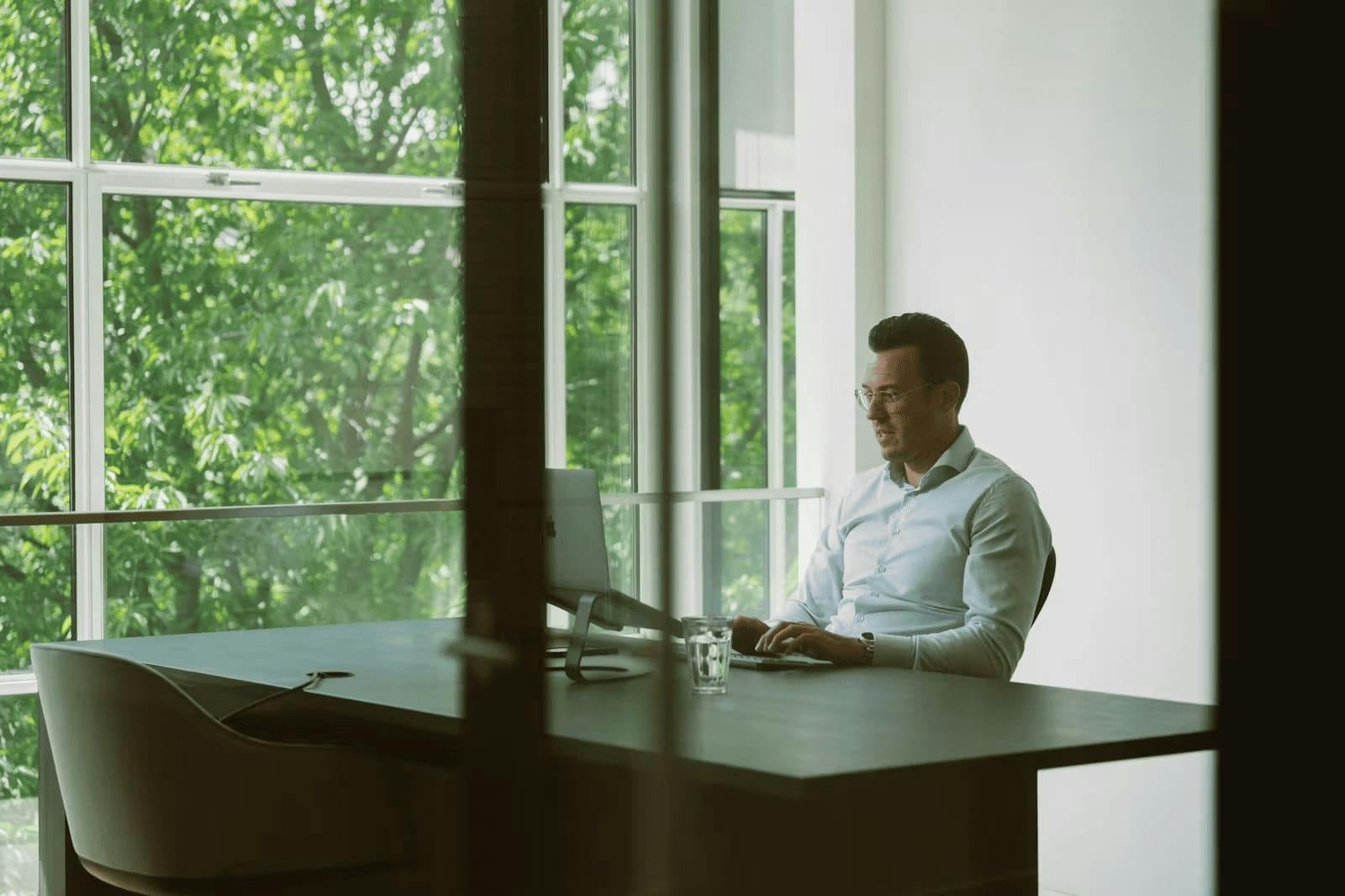 Professional aan het werk achter laptop op het kantoor van Elevation Partners.