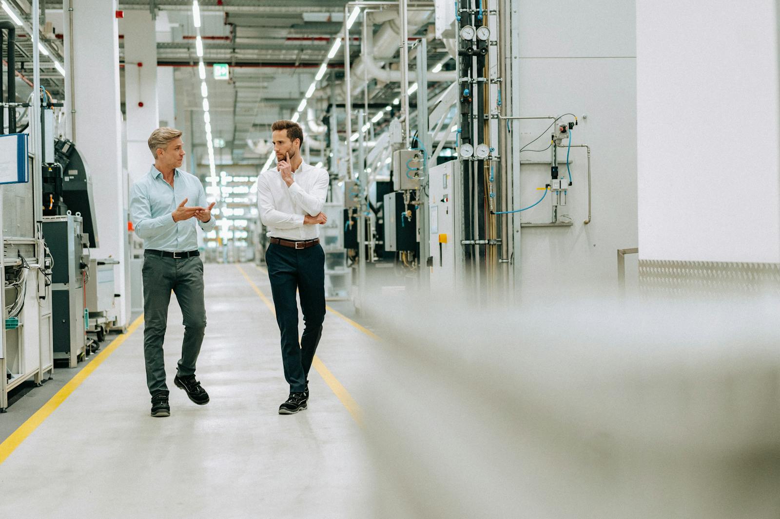 Twee mannen die in gesprek zijn in een fabriek.